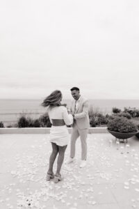 Intimate San Clemente beach proposal with Jeremy on one knee as luxury photographer captures authentic moment