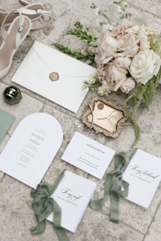 Wedding detail flatlay of rings florals and invitation suite at Stonebridge Manor Mesa Arizona wedding photography
