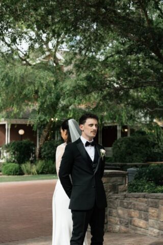 Wedding first touch bride and groom holding hands around corner at Stonebridge Manor Mesa Arizona documentary wedding photographer Meghan GeRue Photo