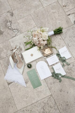 Wedding detail flatlay of rings florals and invitation suite at Stonebridge Manor Mesa Arizona wedding photography
